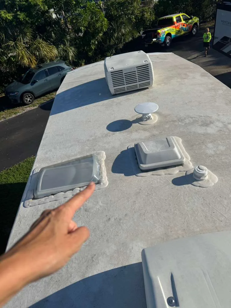 Coast to Coast RV technician repairing a rubber roof leak on an RV in Florida
